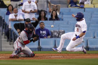 Los Angeles Dodgers' AJ Pollock, right, scores on a single by Zach McKinstry as Washington Nationals catcher Yan Gomes can't hold on to the throw during the second inning of a baseball game Saturday, April 10, 2021, in Los Angeles. (AP Photo/Mark J. Terrill)