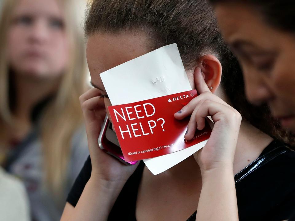 A woman on the phone at an airport, Delta flight delay