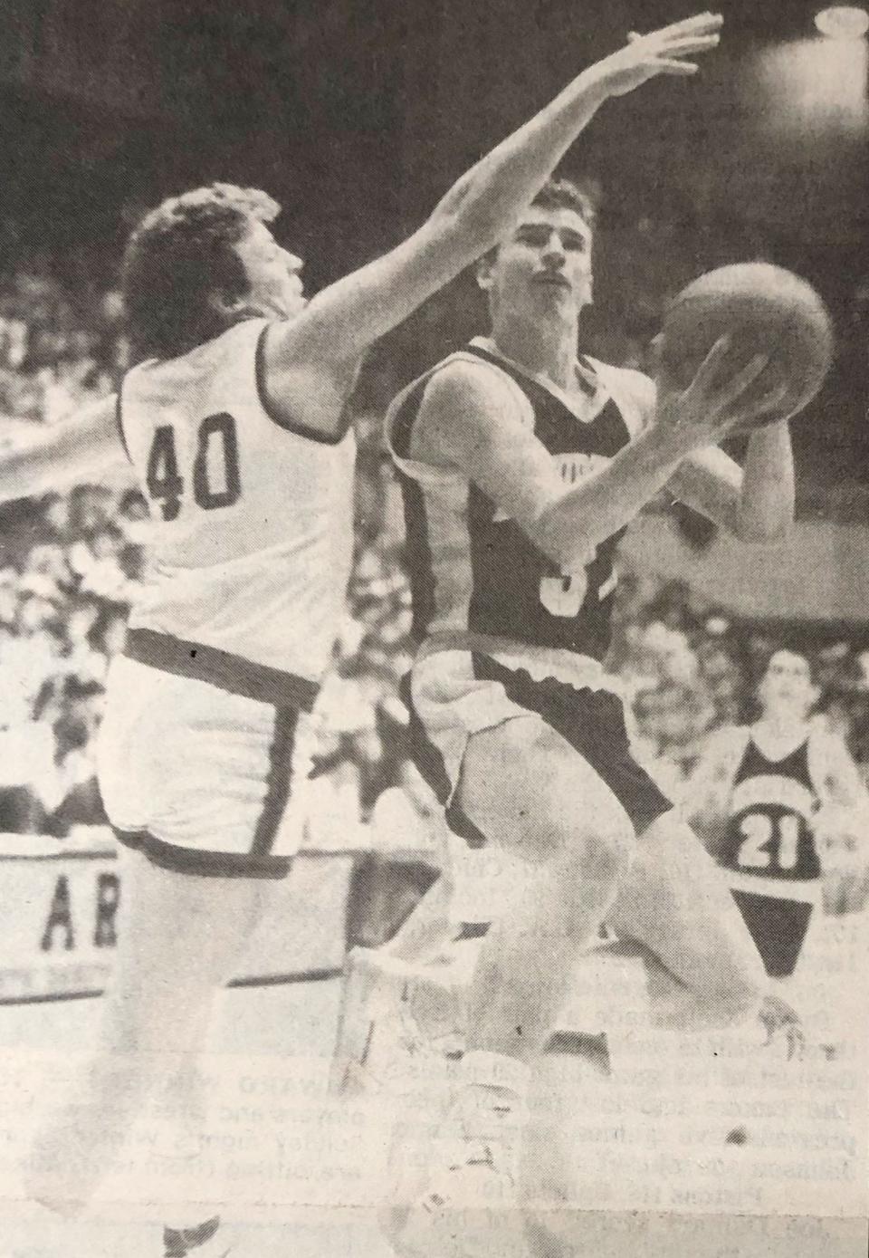 Deubrook's Maurice Petersen drives against Midland's Richard Butler during the championship game of the 1988 state Class B boys basketball tournament in the Huron Arena.