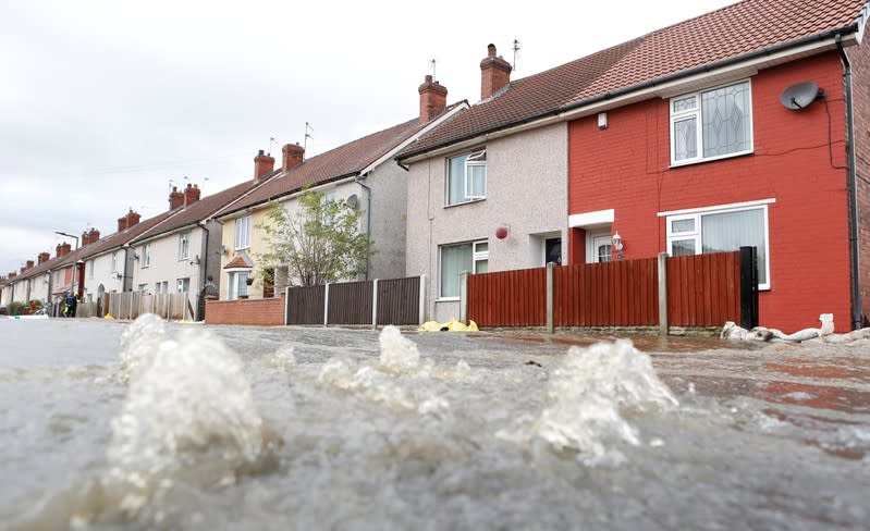 Water flows from the drain on a flooded street of Bentley