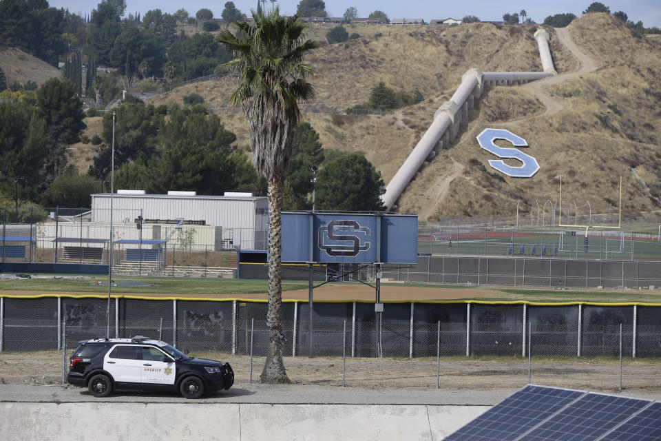 A Los Angeles Sheriff Sheriff's vehicle patrols the surroundings of the Saugus High School in Santa Clarita, Calif., Friday, Nov. 15, 2019. Investigators said Friday they have yet to find a diary, manifesto or note that would explain why a boy killed two students outside the Southern California high school on his 16th birthday. (AP Photo/Damian Dovarganes)