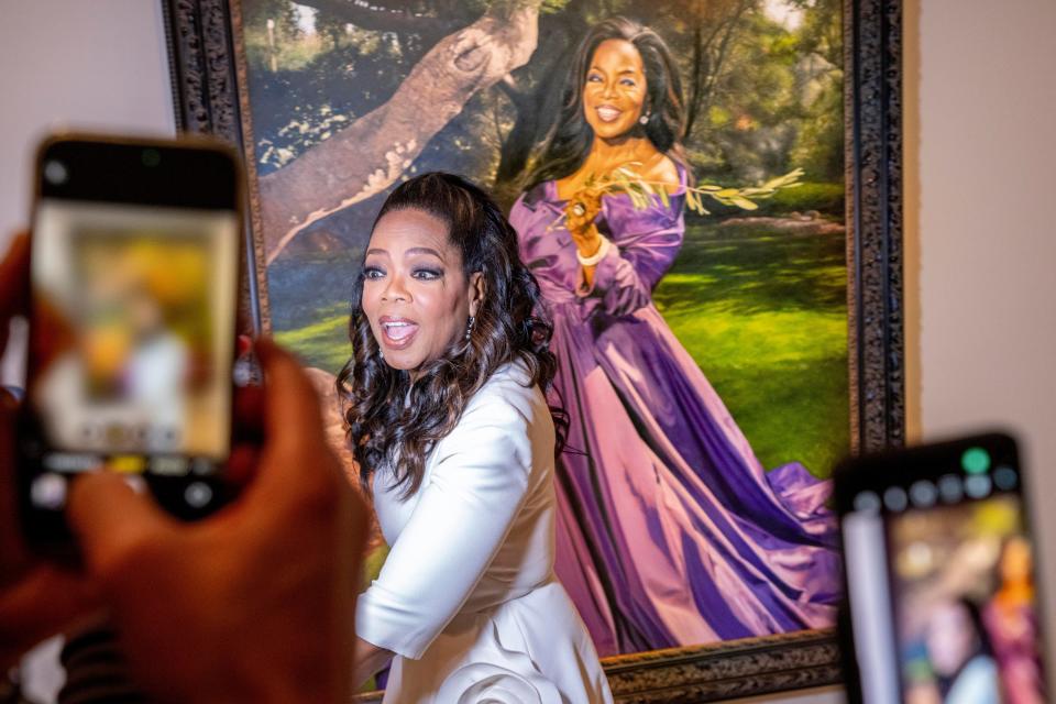 People take photos of Oprah Winfrey at her newly installed portrait by artist Shawn Michael Warren on Dec. 13, 2023, during a portrait unveiling ceremony at the Smithsonian's National Portrait Gallery in Washington.