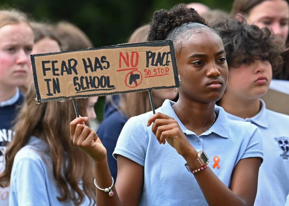 Trinity Episcopal School seventh grader Jade Watkins holds a sign during a student walk out on Wednesday. The students held a walk out to demand action on gun violence and gun safety.