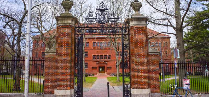 Brick pillar and wrought iron fence entrance to Harvard.