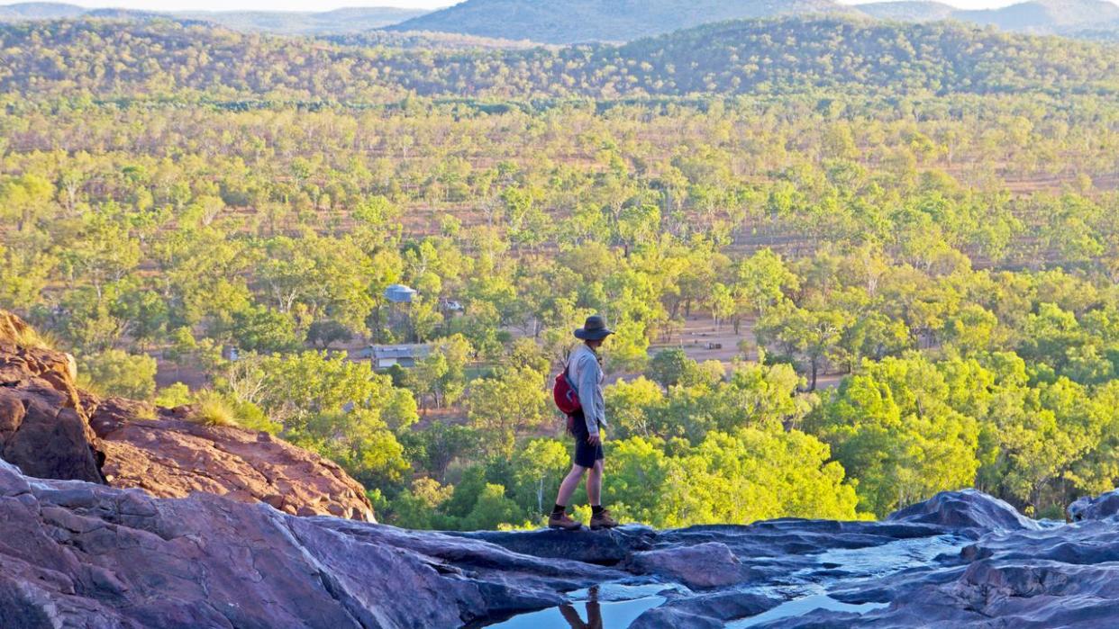 Woman walking across the top of the waterfall at Gunlom in Kakadu National Park. Image shot 2014. Exact date unknown.