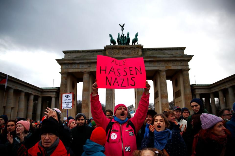 A demonstrator holds a placard in German saying "Everyone hates Nazis" during a pro-democracy demonstration in front of the Brandenburg Gate following allegations that members of the Alternative for Germany (AfD) political party recently met with known neo-Nazis on Jan. 14, 2024 in Berlin, Germany. (Maryam Majd/Getty Images)