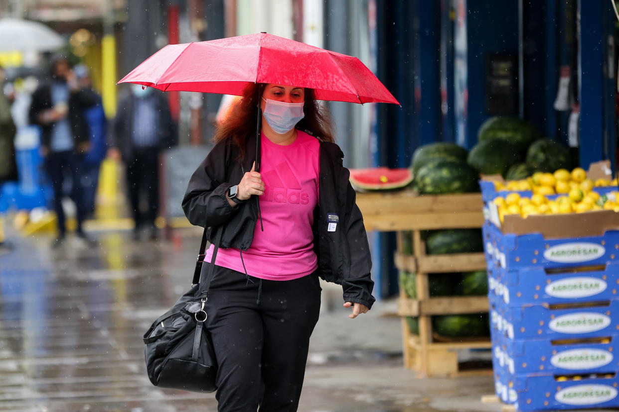 A woman shelters from rain beneath an umbrella in London. (Photo by Dinendra Haria / SOPA Images/Sipa USA)