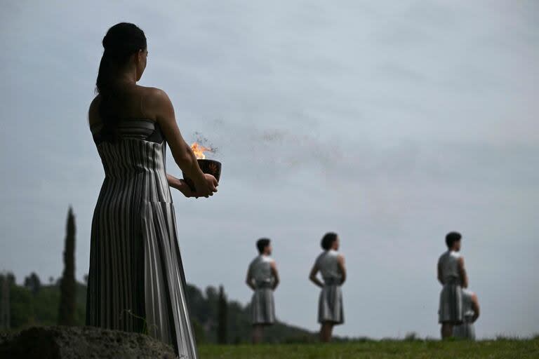 Greek actress Mary Mina, playing the role of the High Priestess, holds the Olympic flame during the Olympic torch lighting ceremony for the Paris 2024 Olympics Games at the Ancient Olympia archeological site, birthplace of the ancient Olympics in southern Greece, on April 16, 2024. (Photo by Aris MESSINIS / AFP)