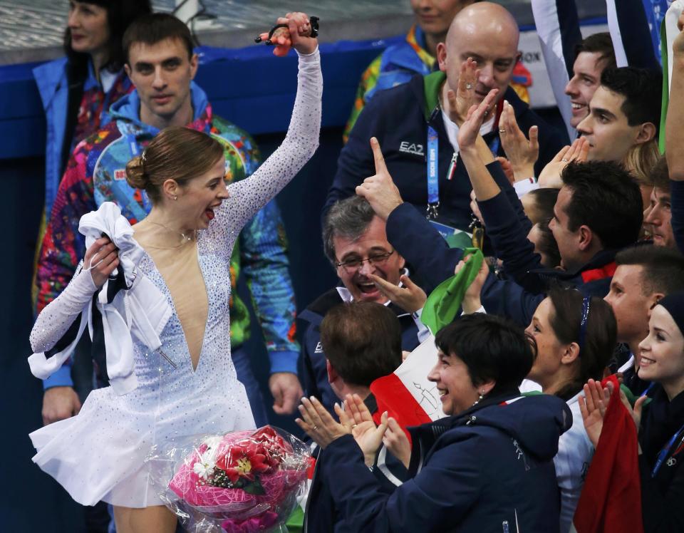 Carolina Kostner of Italy is greeted by her teammates in the "kiss and cry" area during the Team Ladies Short Program at the Sochi 2014 Winter Olympics, February 8, 2014. REUTERS/David Gray (RUSSIA - Tags: SPORT FIGURE SKATING SPORT OLYMPICS)