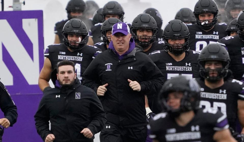Northwestern Wildcats head coach Pat Fitzgerald (center) takes the field with his team against the Ohio State Buckeyes at Ryan Field.
