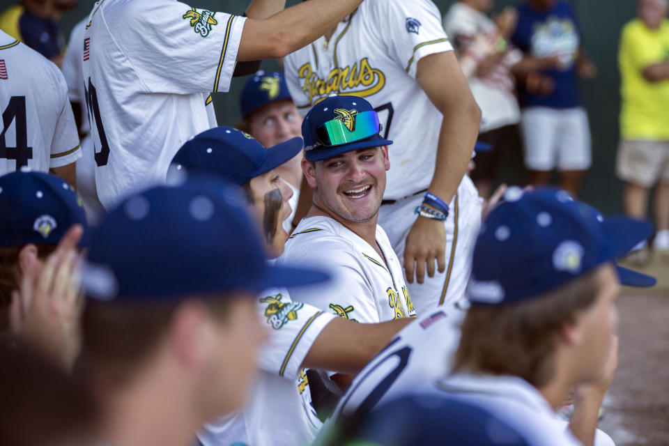 Savannah Bananas pitcher Nolan Daniels, center, laughs with teammates on the bench before the team's baseball game against the Florence Flamingos, Tuesday, June 7, 2022, in Savannah, Ga. (AP Photo/Stephen B. Morton)