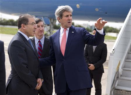 U.S. Secretary of State John Kerry (R) talks with Tunisian Foreign Minister Mongi Hamdi (L) and U.S. Ambassador to Tunisia Jake Walles after arriving at El Aouina Air Base in Tunis February 18, 2014. REUTERS/Evan Vucci/Pool