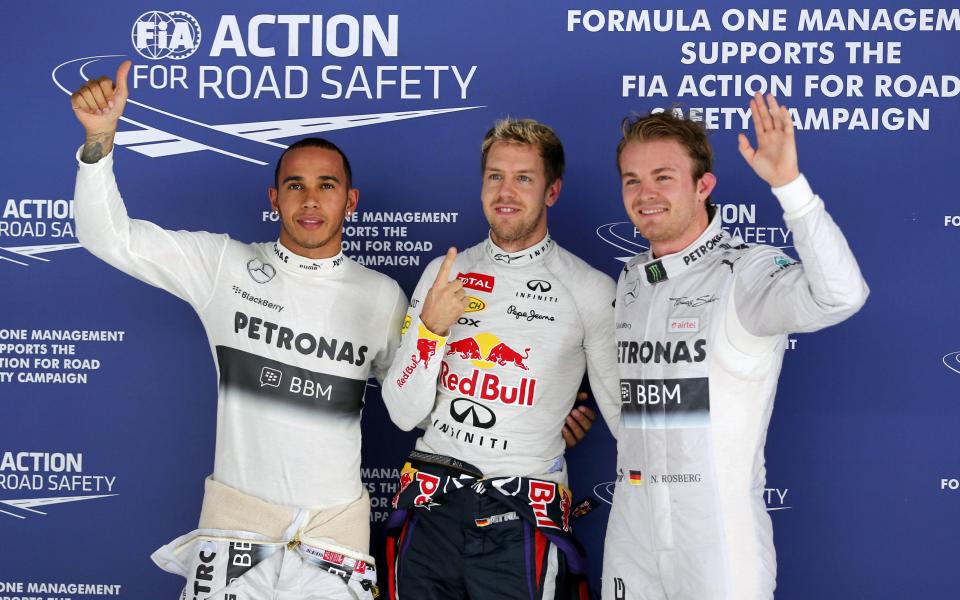 (L-R) Mercedes Formula One driver Lewis Hamilton of Britain, Red Bull Formula One driver Sebastian Vettel of Germany and Mercedes Formula One driver Nico Rosberg of Germany pose for photographers after the qualifying session of the Indian F1 Grand Prix at the Buddh International Circuit in Greater Noida, on the outskirts of New Delhi, October 26, 2013. Vettel put himself on pole position for a fourth successive Formula One title after lapping the Indian Grand Prix circuit faster than ever before on Saturday. REUTERS/Ahmad Masood (INDIA - Tags: SPORT MOTORSPORT F1)