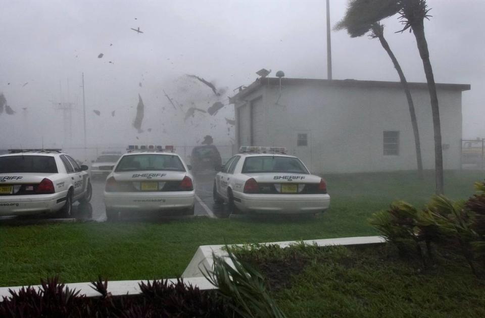 The roof of a garage is blown off onto Charlotte County Sheriff’s cruisers from winds of Hurricane Charley in the parking lot of the Charlotte County Airport, Friday, Aug. 13, 2004, in Punta Gorda,Fla.