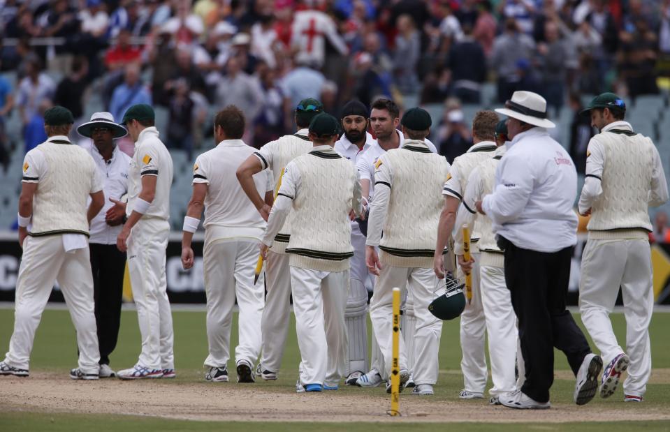 England's James Anderson and Monty Panesar (both C, facing camera) shake hands with the Australia team after losing the second Ashes cricket test at the Adelaide Oval December 9, 2013. Australia captured England's four remaining wickets before lunch to close out an emphatic 218-run victory in the second Ashes test on Monday. REUTERS/David Gray (AUSTRALIA - Tags: SPORT CRICKET)