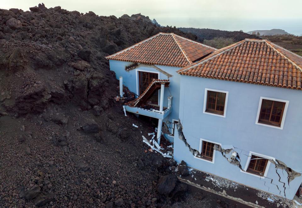 Lava engulfs a house on the Canary island of La Palma, Spain,