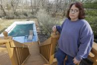 Regina Bachman stands on her deck overlooking her backyard and a small creek that runs behind her home in Loveland, Ohio on Friday, March 21, 2014. Bachman bought the home in September 2013 and was initially told by the bank that flood insurance on the property would be affordable, only to find out after closing that the rates were going to increase over $7,000 more annually with new premiums for the National Flood Insurance Program. (AP Photo/Al Behrman)