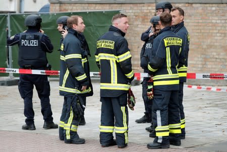 Fire fighters stand near the site of a shooting in Halle