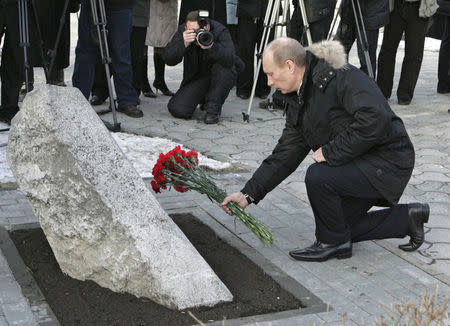 Russian President Vladimir Putin lays flowers at a memorial for victims of local food riots brutally suppressed by the Soviet Army in 1962, in Novocherkassk, in Rostov-on-Don region, Russia, February 1, 2008. Mikhail Klimentyev/Sputnik/Kremlin via Reuters