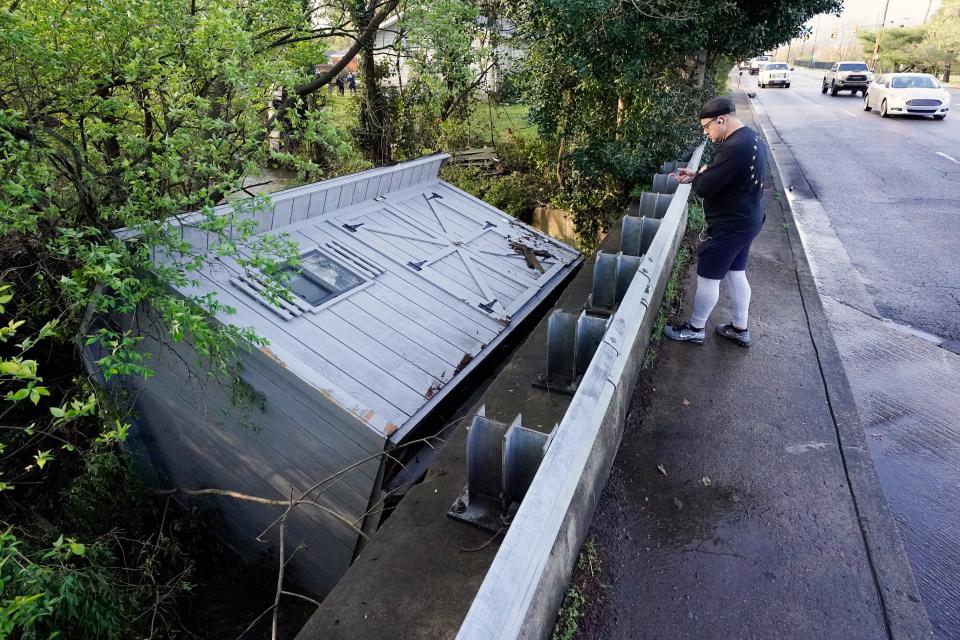 Adam Wirdzek stops to look at a utility building that was carried down a flooded creek Sunday, March 28, 2021, in Nashville, Tenn. Heavy rain across Tennessee flooded homes and roads as a line of severe storms crossed the state.