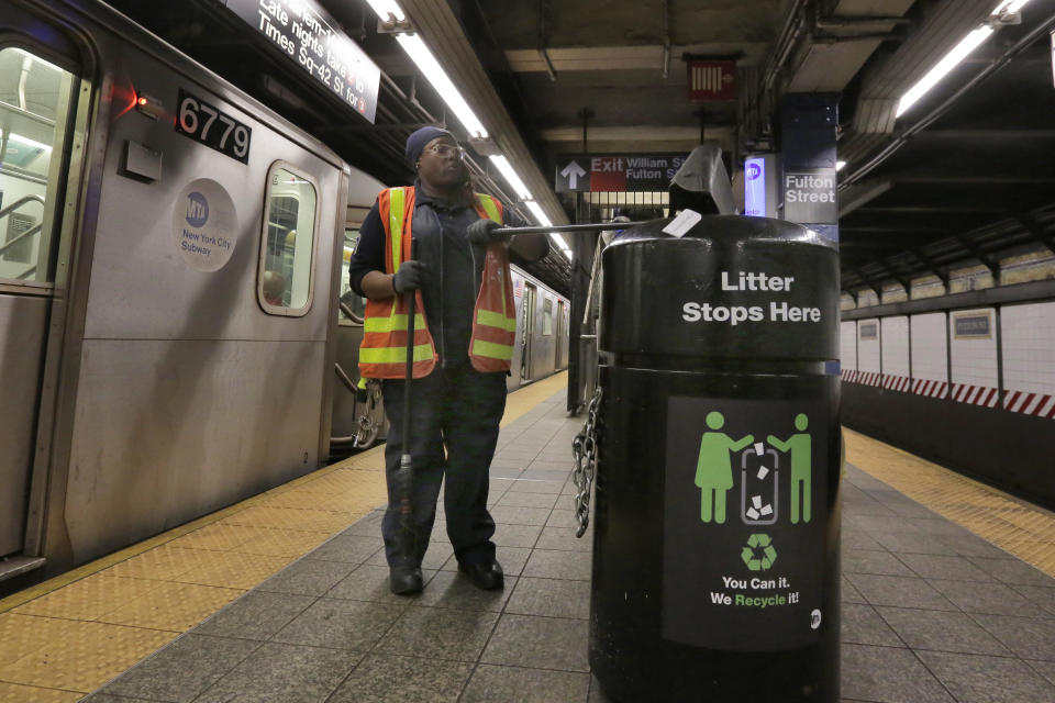 A New York City subway cleaner empties her collection in a trash can in the Fulton Street station, in New York, Thursday, March 30, 2017. Faced with the problem of too much litter and too many rats in their subway stations, New York City transit officials began an unusual social experiment a few years ago. They removed trash bins entirely from select stations, figuring it would deter people from bringing garbage into the subway in the first place. This week, they pulled the plug on the program after reluctantly concluding that it was a failure. (AP Photo/Richard Drew)