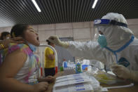 A nurse takes throat swab samples in new round of COVID-19 testing in Nanjing city in eastern China's Jiangsu province Monday, Aug. 2, 2021. The current coronavirus outbreaks in China, while still in the hundreds of cases in total, have spread much more widely than previous ones, reaching multiple provinces and cities including the capital, Beijing. Many of the cases have been identified as the highly contagious delta variant that is driving a resurgence in many countries. (Chinatopix via AP)