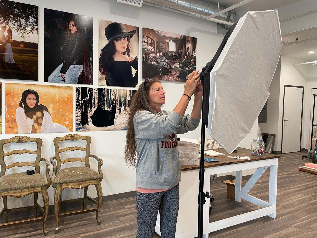 Dawn Flowers adjusts photography equipment at her downtown Brighton studio on Friday, Sept. 8, 2023.