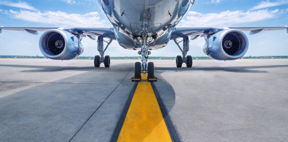 The bottom of an airliner on a runway.