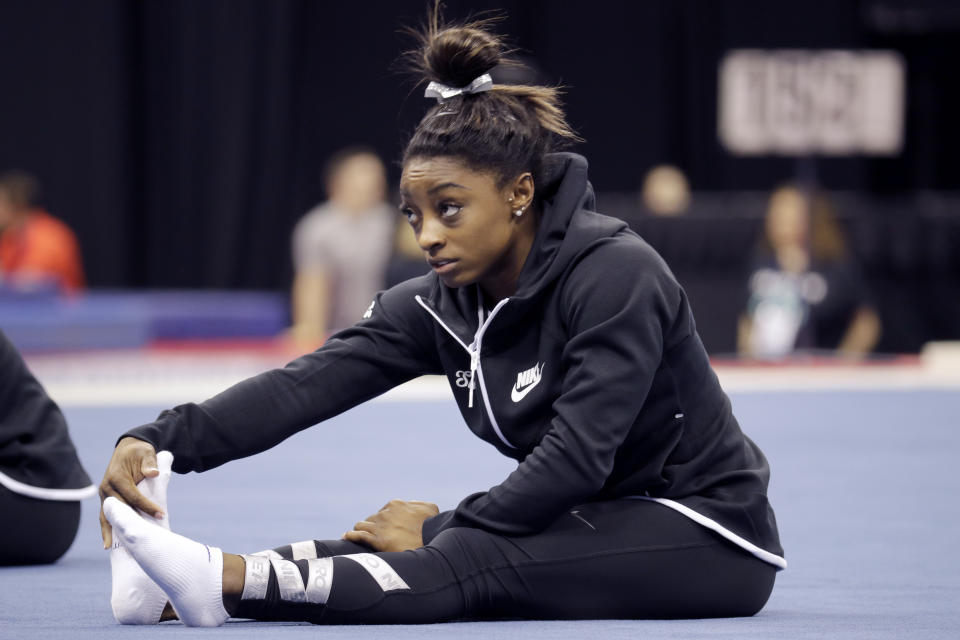 Simone Biles stretches during practice for the U.S. Gymnastics Championships Wednesday, Aug. 7, 2019, in Kansas City, Mo. (AP Photo/Charlie Riedel)