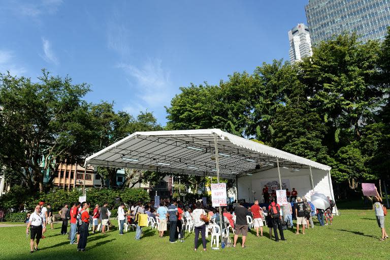 People listen to speakers during a rally at speakers corner in Singapore on October 5, 2013