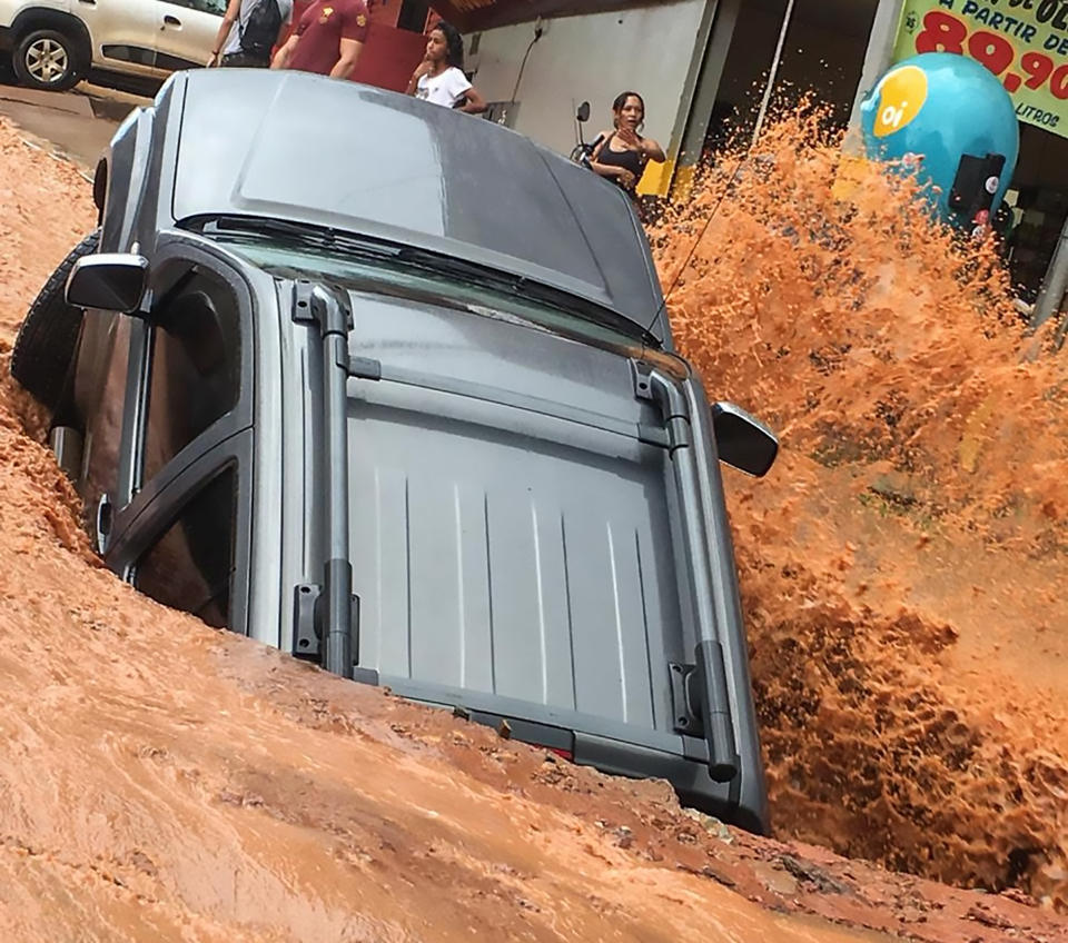 The car dropped into the sinkhole as stunned bystanders gazed on. Source: CEN/ Austrascope