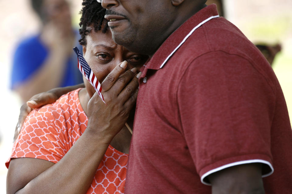 Patricia Olds, a coworker of LaQuita Brown, a victim of a mass shooting at a municipal building in Virginia Beach, Va., is comforted before carrying a cross bearing Brown's name to a nearby makeshift memorial, June 2, 2019. (Photo: Patrick Semansky/AP)