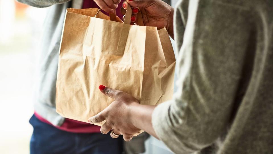 eat out for less: Woman holding paper bag with take out food, home delivery, food order, takeaway