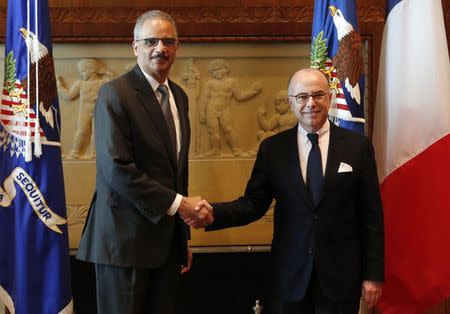 U.S. Attorney General Eric Holder (L) shakes hands with French Interior Minister Bernard Cazeneuve before their meeting at the Justice Department in Washington February 19, 2015. REUTERS/Yuri Gripas
