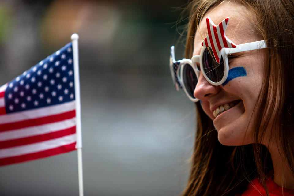 A fan waves a flag along the parade route.&nbsp; (Photo: Demetrius Freeman for HuffPost)