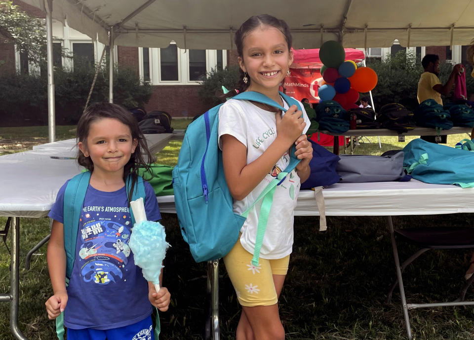 From left, sisters Audrey and Jubilee Colon pick out new backpacks at a Chicago Public Schools back-to-school supply giveaway at Theodore Roosevelt High School in Chicago, on July 22, 2022. This back-to-school shopping season, parents, particularly in the low-to-middle income bracket, are focusing on the basics like no-frills rain boots, while also trading down to cheaper stores, including second-hand clothing, as surging inflation takes a toll on their household budgets. (AP Photo/Claire Savage)