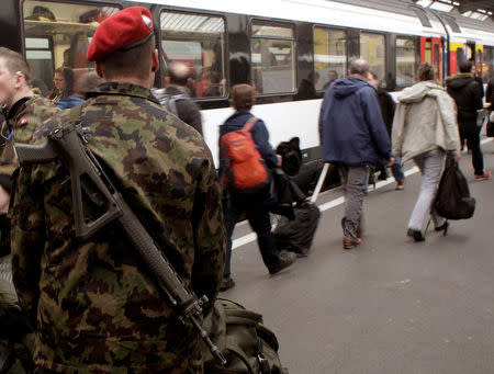 A Swiss soldier carries his assault rifle as he disembarks from a train at the central railway station in Zurich, Switzerland April 5, 2013. To match story SWISS-EU/GUNS REUTERS/Arnd Wiegmann/File Photos