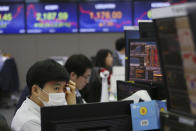 A currency trader wearing a mask watches monitors at the foreign exchange dealing room of the KEB Hana Bank headquarters in Seoul, South Korea, Tuesday, Jan. 28, 2020. Asian shares continued to fall Tuesday, dragged down by worries about an outbreak of a new virus in China that threatens global economic growth. (AP Photo/Ahn Young-joon)