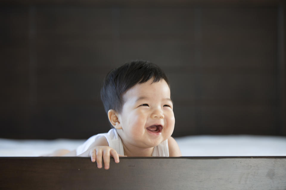 Asian-looking baby, smiling, illustrating a piece on Singapore's Baby Bonus Scheme. 