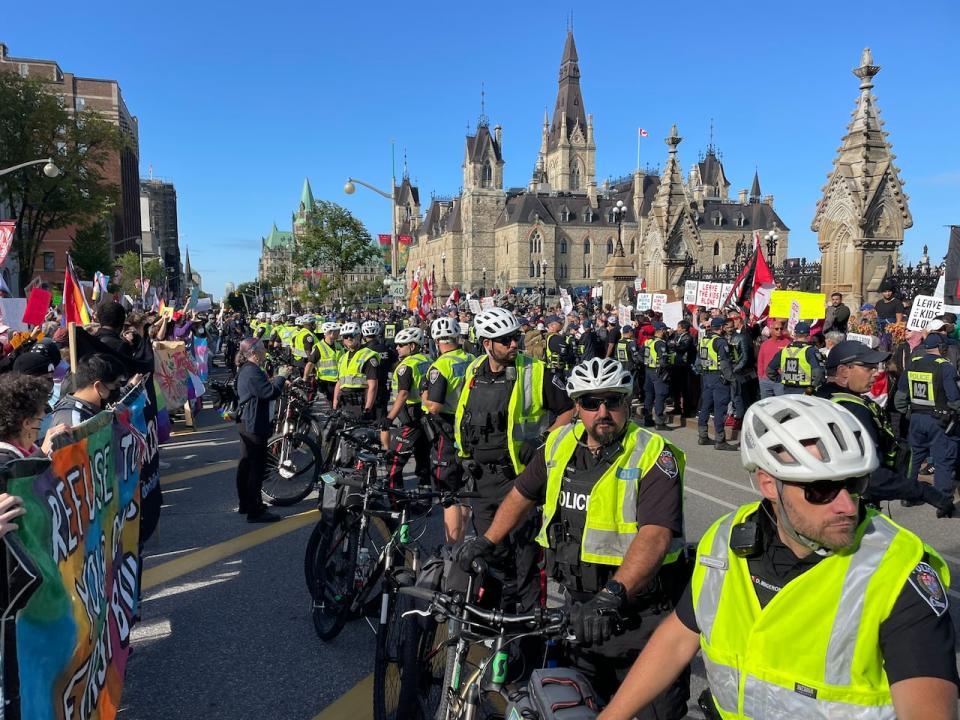 A line of police separate the two groups of demonstrators at Parliament Hill Wednesday.