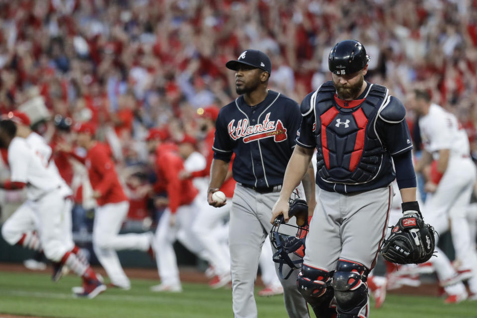 El relevista de los Bravos de Atlanta, el colombiano Julio Teherán, y el receptor Brian McCann, salen del diamante luego de permitir la carrera ganadora durante el 10mo inning del cuarto juego de la Serie Divisional de la Liga Nacional, el lunes 7 de octubre de 2019, en San Luis. (AP Foto, Charlie Riedel)