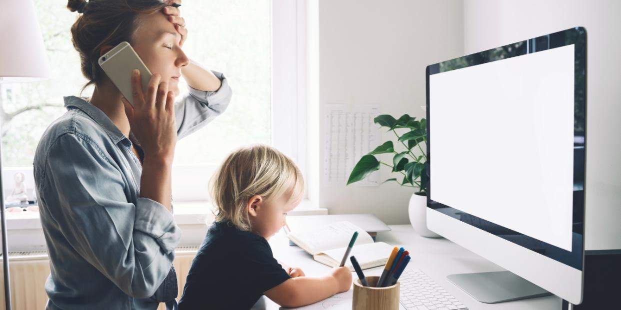 mom on phone working from home with child balancing work with sick child