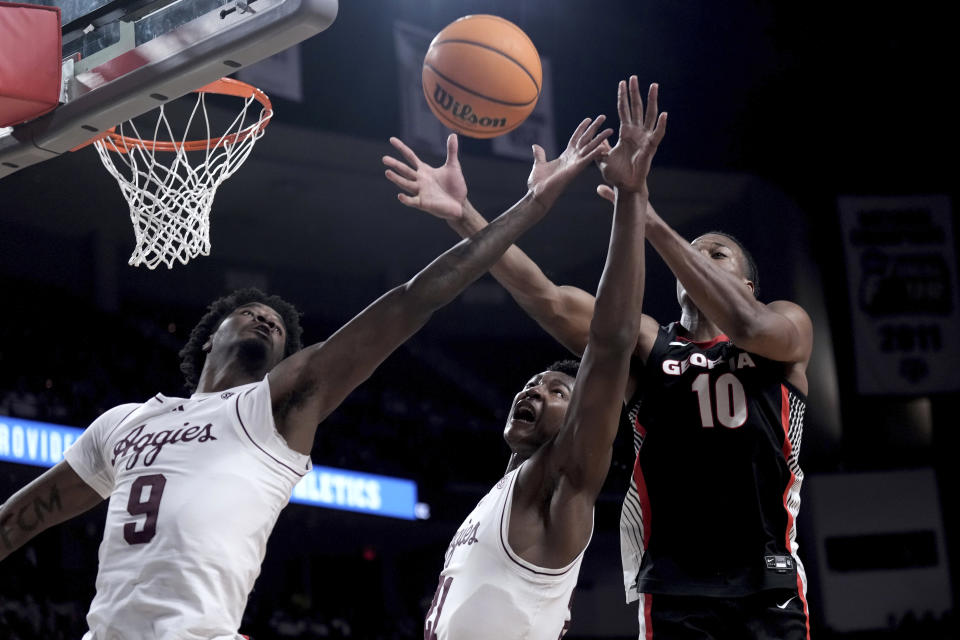 Texas A&M forward Solomon Washington, left, and teammate Pharrel Payne, center, reach for a rebound against Georgia forward RJ Godfrey, right, during the first half of an NCAA college basketball game Tuesday, Feb. 11, 2025, in College Station, Texas. (AP Photo/Sam Craft)