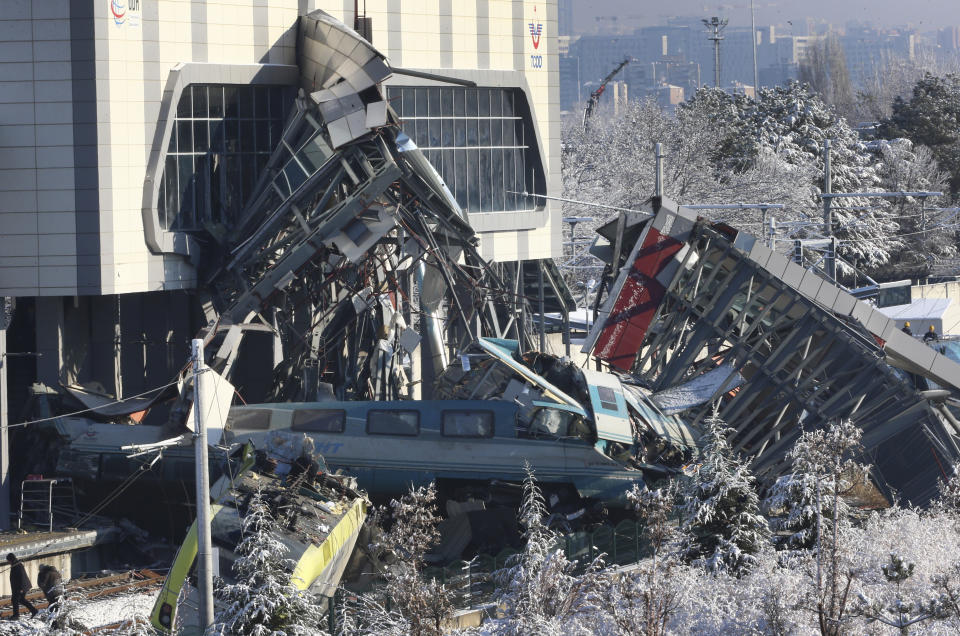 Members of rescue services work at the scene of a train accident in Ankara, Turkey, Thursday, Dec. 13, 2018. A high-speed train hit a railway engine and crashed into a pedestrian overpass at a station in the Turkish capital Ankara on Thursday, killing more than 5 people and injuring more than 40 others, officials and news reports said. (AP Photo/Burhan Ozbilici)