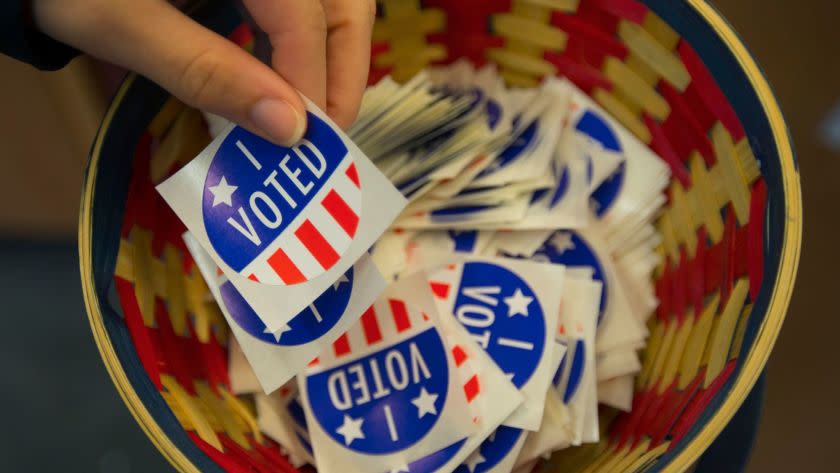 A visitor to the Lane County election offices in Eugene, Ore., helps herself to a "I voted" sticker after casting her ballot on Nov. 7.