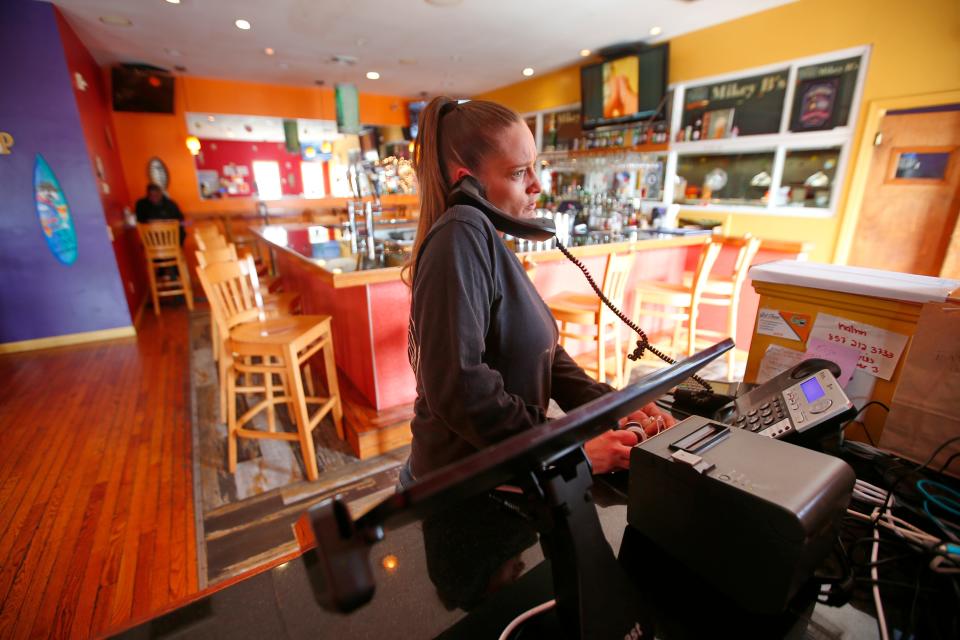 Christine Sharp, manager, takes a phone order at Mikey B's on Victoria Street of Acushnet Avenue in New Bedford.