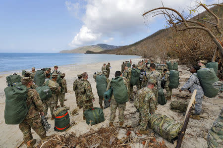 Army soldiers from the 602nd Area Support Medical Company gather on a beach as they await transport on a Navy landing craft while evacuating in advance of Hurricane Maria, in Charlotte Amalie, St. Thomas, U.S. Virgin Islands September 17, 2017. REUTERS/Jonathan Drake