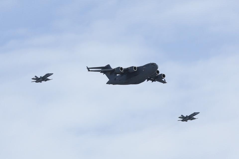 A C-17 transport plane carrying Canadian soldiers from Afghanistan is escorted by CF-18 fighter jets as it prepares to land in Ottawa