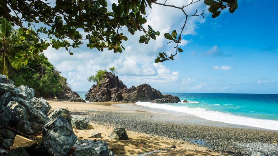 A general view of Turtle Beach, Tobago (also known as Courland Bay) showing sand, rocks, blue sea and sky