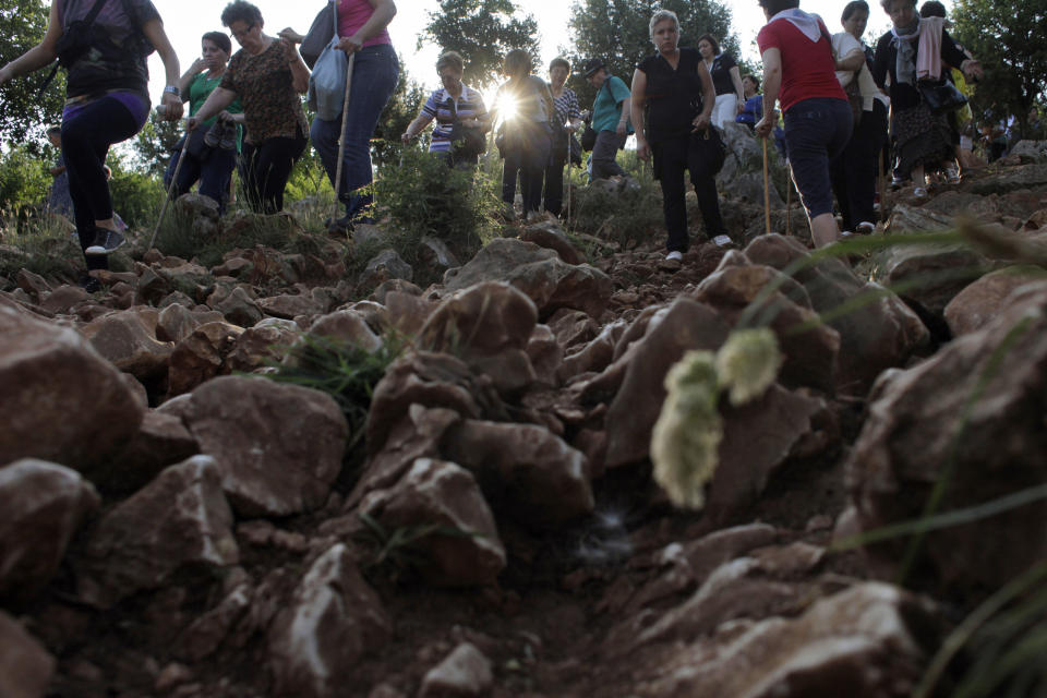Pilgrims walk on a rocky terrain to say their prayers on the Hill Of Appearance in Medjugorje,100 km south of Sarajevo, Monday, June 25, 2012, where it is believed that the Virgin Mary showed herself and conveyed messages of peace to six children on June 25, 1981. On Friday, May 17, 2024, the Vatican will issue revised norms for discerning apparitions "and other supernatural phenomena," updating a set of guidelines first issued in 1978. (AP Photo/Amel Emric, File)